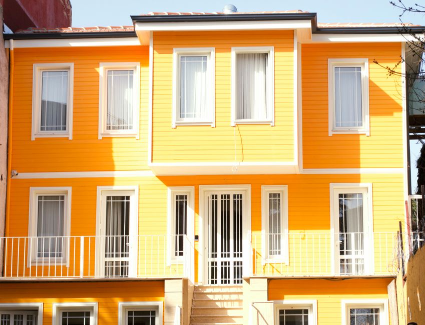 Yellow painted house exterior with white framed windows and door