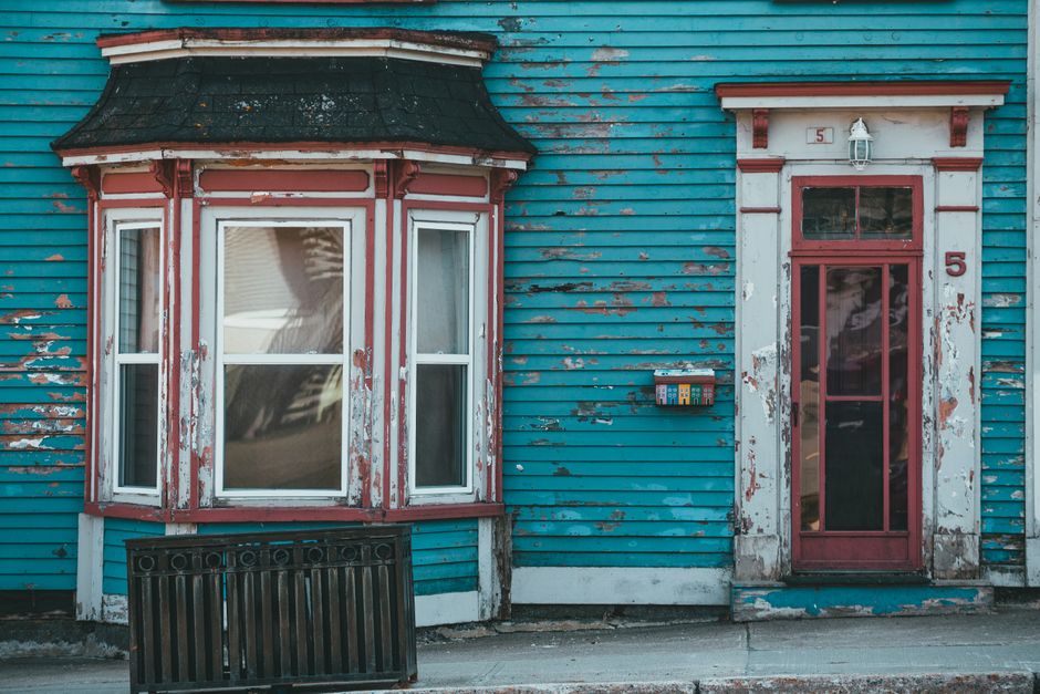 Older house with a painted wall, bow window and front door