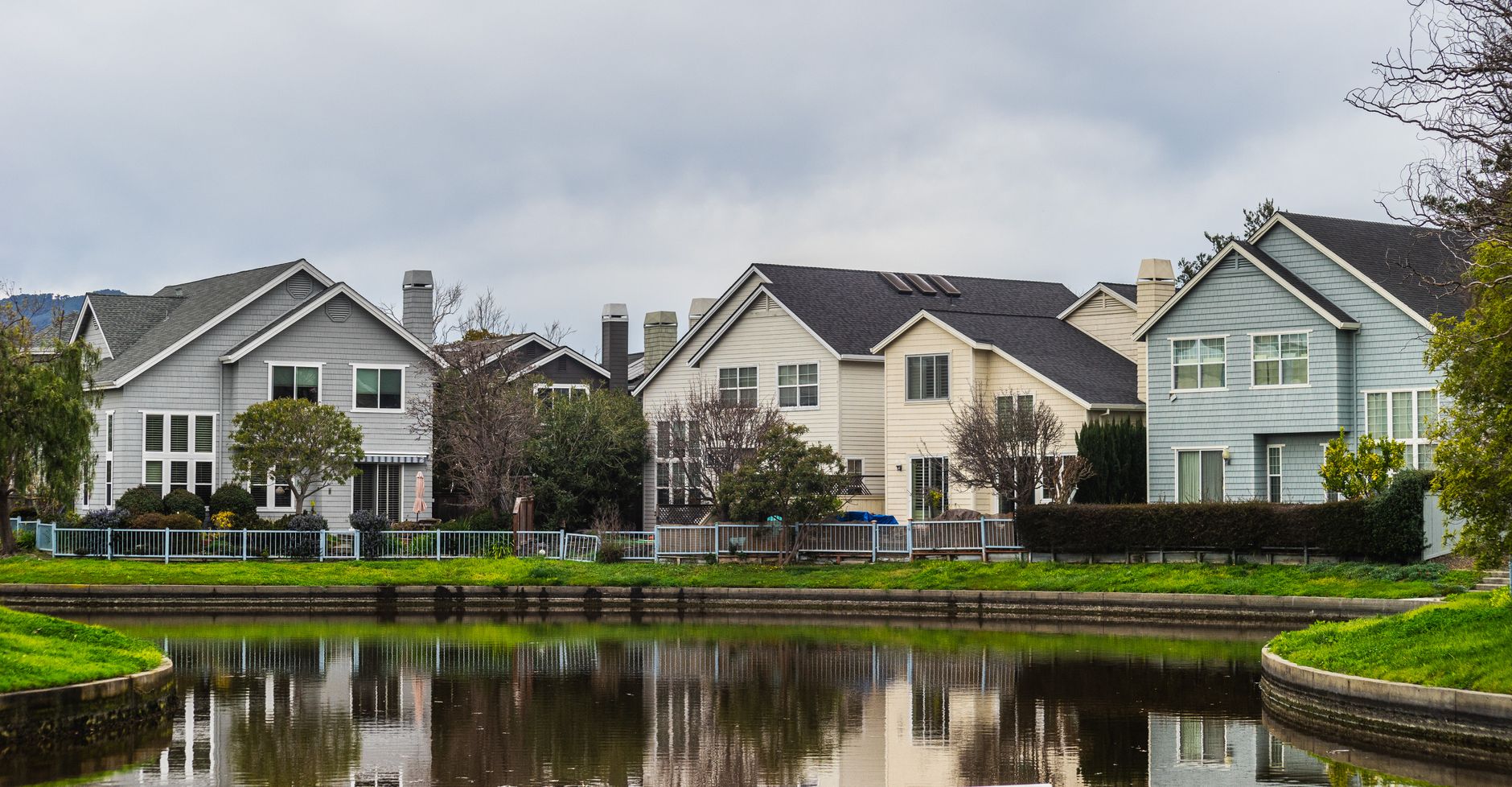 Beautiful suburban houses reflecting in a peaceful riverside setting with lush greenery