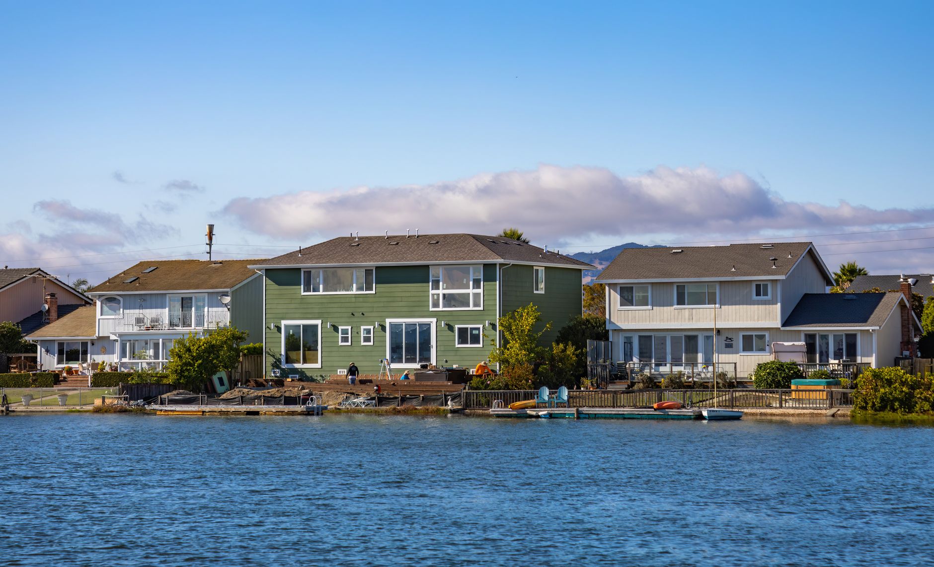 Picturesque riverside homes with clear blue skies and calm water in a peaceful neighborhood