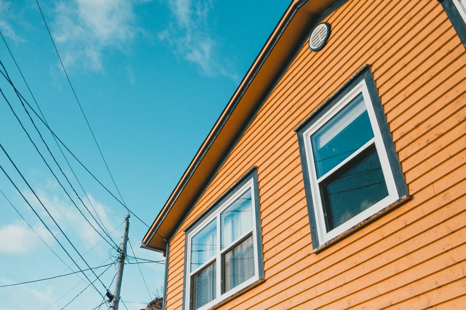 Yellow painted house exterior against a blue sky